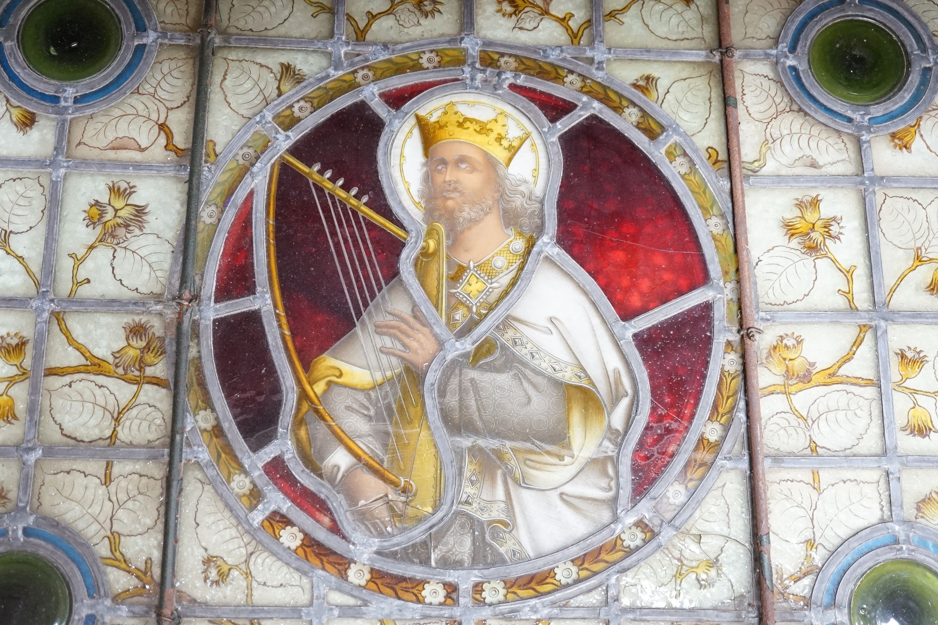 A framed Victorian stained glass panel depicting King David playing the harp, 58x70cm including frame